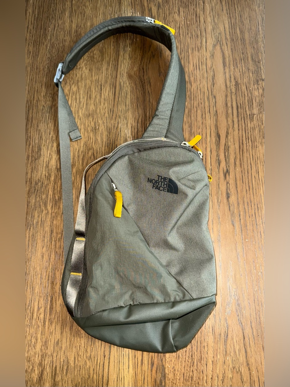 The North Face Olive Sling Bag with Yellow Zipper Accents